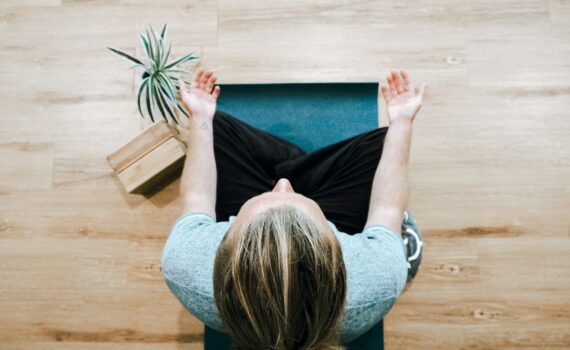 woman in black shirt and gray pants sitting on brown wooden bench