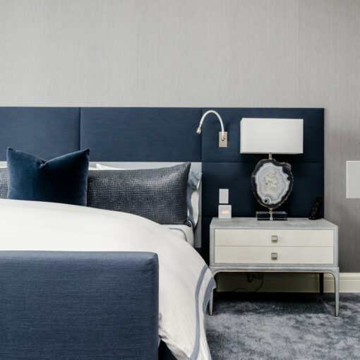 white and clear desk lamp on white wooden nightstand near bed