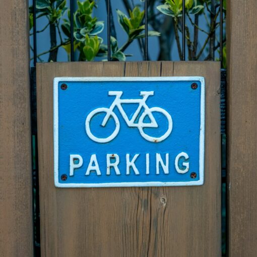 a blue parking sign mounted to a wooden fence